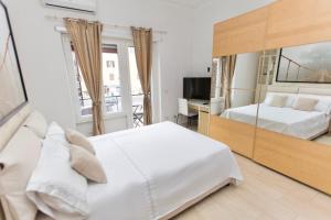 a bedroom with a large white bed and a mirror at San Pietro Home in Rome