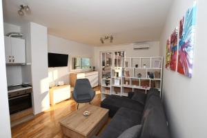 uma sala de estar com um sofá e uma mesa em Sky Way Studio Apartment em Saraievo