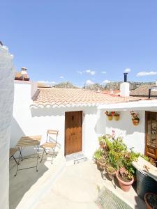 ein weißes Haus mit einem Tisch und Stühlen auf dem Balkon in der Unterkunft Casa El Refugio in Montejaque