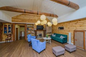 sala de estar con paredes de madera y sillas azules en Yuryevskoye Podvorye Boutique Hotel, en Velikiy Novgorod