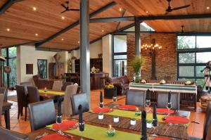 a dining room with tables and chairs in a house at Greenfire Game Lodge in Balule Game Reserve