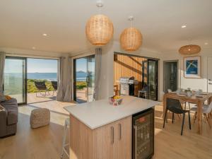 a kitchen and living room with a view of the ocean at Opito Perfection - Opito Bay Holiday Home in Opito Bay