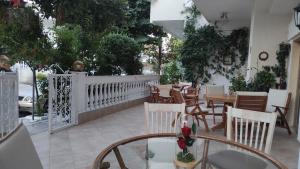 a restaurant with tables and chairs and a white fence at Evripidis – Katerina Rooms –Β in Asprovalta