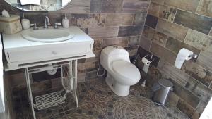 uma casa de banho com um WC branco e um lavatório. em Villa De Coral em Valle de Guadalupe