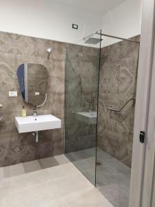 een badkamer met een wastafel en een glazen douche bij Masseria Torre Saracena in Agrigento