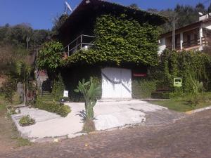 una casa con una puerta blanca y hiedra en Sharing Home I, en Três Coroas