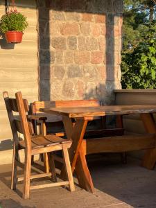 a wooden table and chairs on a patio at wietrznie-wichrowe wzgórze in Wólka Ratowiecka