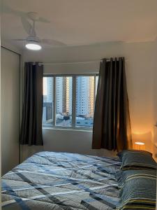 um quarto com uma cama e uma janela em 707- Apartamento Encantador, amplo e decorado, quarto, sala, cozinha, mobiliario moderno, cozinha completa com utensílios , Excelente vista da cidade e localização privelegiada no bairro Bigorrilho em Curitiba