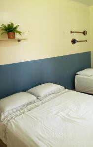 um quarto com 2 camas e uma parede azul em CASA OURO VERDE - Praia de Mosqueiro em Belém