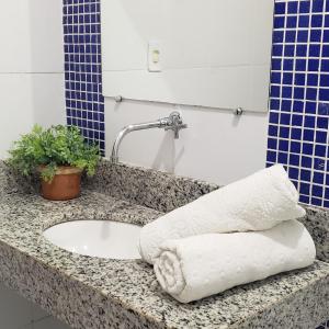um balcão de casa de banho com um lavatório com uma toalha em CASA OURO VERDE - Praia de Mosqueiro em Belém