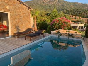 a pool with two chairs next to a house at VILLA PERLA SAINT-TROPEZ CAVALAIRE sur MER, 3-5 chambres, vue mer, piscine chauffée avril à octobre in Cavalaire-sur-Mer