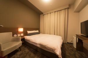 a hotel room with a bed and a television at Dormy Inn Premium Shibuya-jingumae in Tokyo