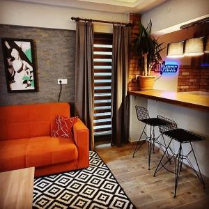 a living room with an orange couch and a kitchen at Akdeniz apart hotel in Marmaris