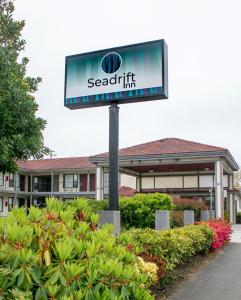 una señal para una posada scarrett frente a un edificio en Sea Drift Inn, en Eureka
