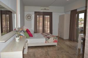 sypialnia z łóżkiem z czerwonymi poduszkami w obiekcie Attalos Apartments w mieście Agia Pelagia