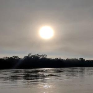 un coucher de soleil sur une masse d'eau dans l'établissement Hospedaje KOWAPANA BOCAS DE AMACAYACU, à Morelia