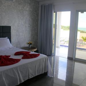 a bedroom with a bed with a red blanket on it at Vilamar in Tibau do Sul