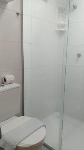 a bathroom with a toilet and a glass shower at Charmoso Apt 412 in João Pessoa