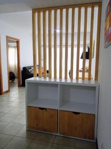 a white shelf in a living room with a staircase at Appartement in the Main Street with elevator access in Ushuaia