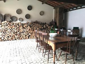 a wooden table with chairs and a pile of wood at Casa dos meus avós - AL & Events in Vila Nova de Gaia