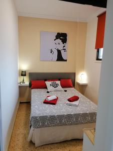 Un dormitorio con una cama con almohadas rojas. en Ancorà Angela - Playa del Inglès, en Maspalomas