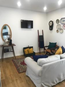 a living room with two white couches and a mirror at Casa dos meus avós - AL & Events in Vila Nova de Gaia