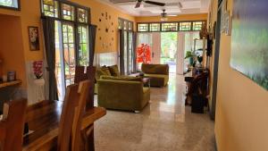 a living room with couches and chairs and windows at Dewi Sri Guesthouse in Mataram