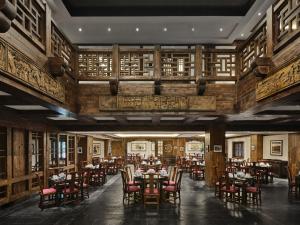 a dining room with tables and chairs and wooden walls at InterContinental Resort Jiuzhai Paradise by IHG in Jiuzhaigou