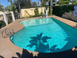 a blue swimming pool with a palm tree in it at Legacy inn & suites in Anaheim