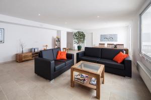 a living room with two black couches and a table at Hotel Nou Estrelles in Cadaqués