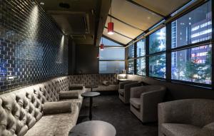 a restaurant with chairs and tables and windows at Cross Hotel Osaka in Osaka