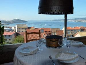 a table with wine glasses and a view of the ocean at Bahia de Chapela in Redondela +21 photos