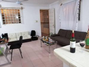 a living room with a couch and a table with a bottle of wine at Private Room in Cozumel