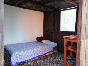 a small bedroom with a bed and a desk at Sustainable Cabain in Cozumel