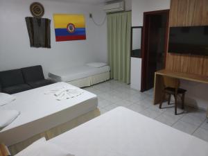 ein Wohnzimmer mit 2 Betten und einem Flachbild-TV in der Unterkunft Hotel Iguaçu in Dionísio Cerqueira