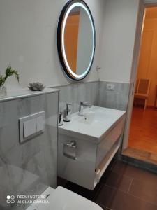 uma casa de banho com um lavatório e um espelho em Vila Essel em Korçë