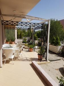 a patio with white chairs and a table and ailion at Vila Essel in Korçë