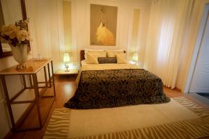 a bedroom with a bed and two tables with lamps at Vila Essel in Korçë