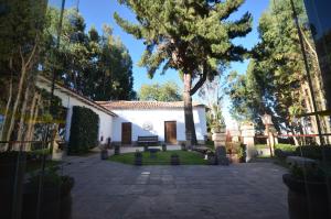 a courtyard with a tree and a white building at Palacio Manco Capac by Ananay Hotels in Cusco