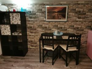 a black dining room table and chairs with a brick wall at Wohnung Nähe Losheimer Stausee in Niederlosheim