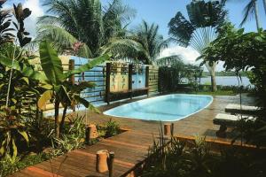 a swimming pool in a yard with a wooden deck at Casa de Temporada 4 Coqueiros, Piscina, 16 Hóspedes, 4 Suítes e Churrasqueira em Itacaré na Bahia in Itacaré +44 photos