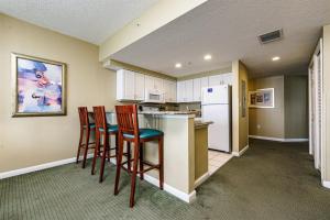 a kitchen with two chairs and a counter with a refrigerator at Unit 2427 Ocean Walk - 2 Bedroom Ocean Front in Daytona Beach