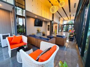 a lobby with wicker chairs and orange pillows at UR The Private Huahin in Hua Hin