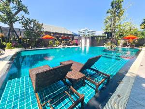 a swimming pool with two chairs and a table in it at UR The Private Huahin in Hua Hin
