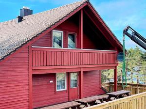 uma casa vermelha com uma mesa de piquenique em frente em 27 person holiday home in dyrdal em Frafjord