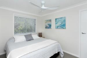 Säng eller sängar i ett rum på The Sands Mollymook Luxury Beach House