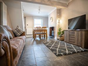 a living room with a couch and a flat screen tv at Tramway Cottage in Llandudno