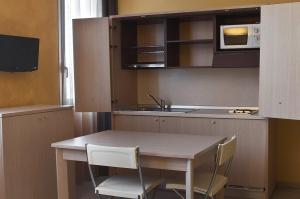 cocina con mesa, sillas y microondas en Silver Residence Hotel, en Bagnolo in Piano