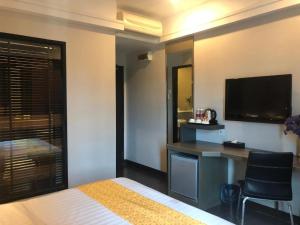 a hotel room with a bed and a desk and a television at De Hotel Ipoh in Ipoh