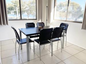 een eetkamer met een blauwe tafel en stoelen bij Cloud 8 on Welsby in Bongaree